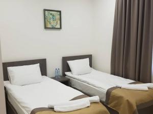 2 camas en una habitación de hotel con sábanas blancas en Hotel Classic, en Tiflis