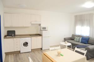 a living room with a couch and a kitchen at Apartamentos El Marinero - Iglesia in Caleta de Sebo