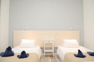 Dos camas en una habitación con almohadas azules. en Apartamentos El Marinero - Iglesia, en Caleta de Sebo