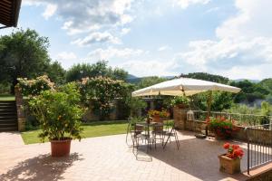 a patio with an umbrella and a table and chairs at La Villa di Primo in Cavriglia