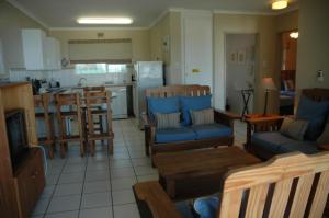 a kitchen with wooden chairs and a kitchen with a kitchen at Ramsgate Palms D in Ramsgate