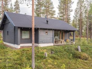 a black cabin in the middle of a forest at Holiday Home Neljä vuodenaikaa a1-karpalo by Interhome in Ylläsjärvi