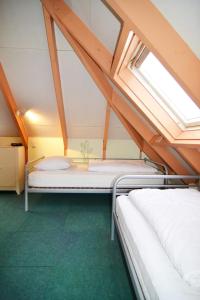two beds in a attic room with a window at Bungalowpark De Toekomst in Ouddorp