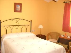 een slaapkamer met een bed, een tafel en een stoel bij Casa Rural El Balcón de Cazorla in Tiscar