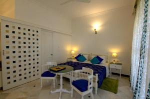 1 dormitorio con 1 cama, mesa y sillas en Aashray en Varanasi