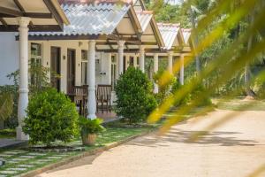 a house with white columns and a porch at Luna Beach Hotel in Nilaveli