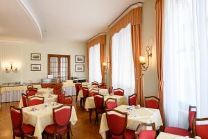 a dining room with tables and red chairs at Hotel Continental in Treviso