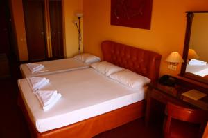 a bed with two pillows on it in a room at Galini Palace in Athens
