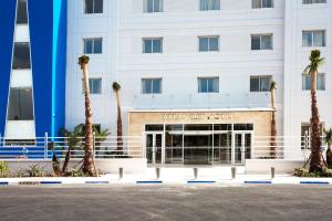 a building with palm trees in front of it at Sky Casa Airport in Nouaseur