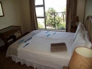 a bedroom with a white bed with a window at Ramsgate Palms J in Ramsgate