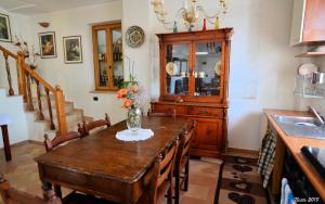 a kitchen with a wooden table with a vase of flowers on it at Villa Radiosa in Gravina in Puglia