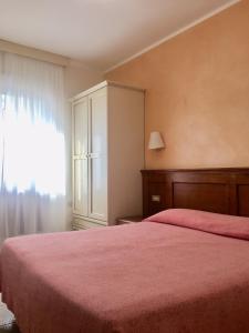 a bedroom with a large bed with a red blanket at Hotel Sporting in Roccaraso