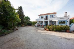 a large white house on a dirt road at Sintra Farm Villa Guest House in Sintra