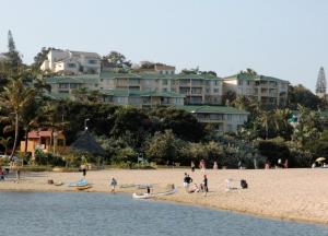 a group of people on a beach with buildings in the background at Ramsgate Palms 75 in Ramsgate