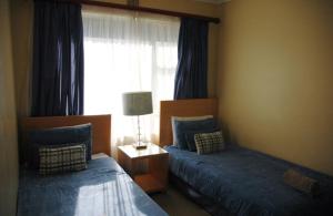 a bedroom with two beds and a window at Ramsgate Palms H in Ramsgate