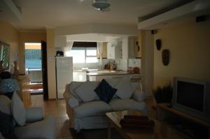 a living room with a couch and a kitchen at Ramsgate Palms H in Ramsgate