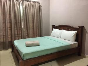 a bedroom with a bed with a pillow on it at Harmony Guesthouse Sdn Bhd in Kampung Padang Masirat