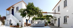 um pátio de um edifício branco com uma cama em Oryza Guest House& Suites em Coimbra