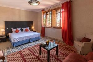 a hotel room with a bed and a table at Hôtel Riad Airport Marrakech in Marrakech +37 photos