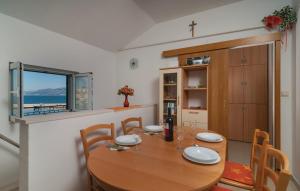 a dining room with a wooden table and a window at Direct At Sea in Postira