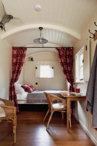 a small bedroom with a bed and a table at The Huts in the Hills in Llanigon