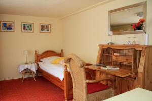 a bedroom with a bed and a desk with a mirror at Hotel Zum Römer in Überlingen