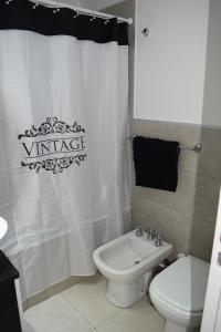 a bathroom with a white toilet and a shower curtain at Apartamento en el centro de Banfield in Banfield +11 photos