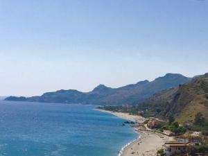 フォルツァ・ダグロにあるAppartamento Taormina Mareの山々を背景に広がるビーチの景色