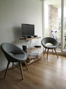 2 sillas en una sala de estar con TV en Papudo para 6 personas - PLAYA Y BOSQUE a metros, en Papudo