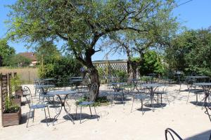 a group of tables and chairs under a tree at Adéloïa Cottage in Fauverney