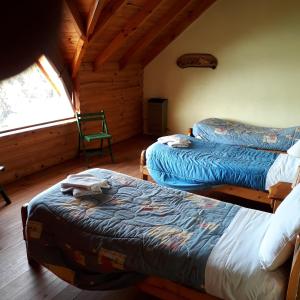 um quarto com 2 camas e uma janela num camarote em Cabañas Bahia Radal em Villa Pehuenia