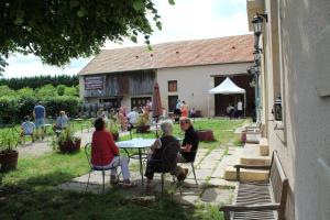 a group of people sitting at a table outside a building at Le Fauverney Lodge in Fauverney