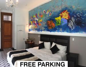 1 dormitorio con 1 cama y una gran pintura en la pared en Casa Puente Hotel Boutique, en Valparaíso