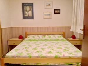 Ce lit se trouve dans une chambre dotée de 2 tables de chevet et d'un lit fleuri. dans l'établissement Appartamento Taormina Mare, à Forza dʼAgro