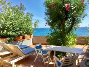 une terrasse avec une table et des chaises et l'océan dans l'établissement Appartamento Taormina Mare, à Forza dʼAgro