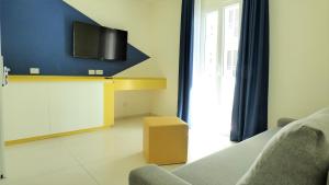 ベッラーリア・イジェア・マリーナにあるHotel Treviのソファと壁掛けテレビのあるリビングルーム