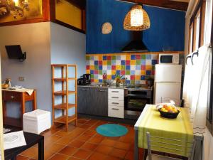 une cuisine avec une table et une cuisine aux murs bleus dans l'établissement Apartamentos Rurales KNICASIA, à Quintueles