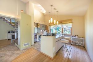 a kitchen and living room with a counter and chairs at Villa EverGreen near the city center with private garden, hot tub, garage parking, patio in Vilnius