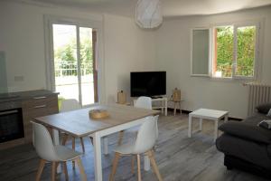 - un salon avec une table et des chaises en bois dans l'établissement BdB nid douillet au rdc rando ressourçante, à Bagnères-de-Bigorre