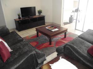 a living room with two couches and a coffee table at Santorini E in Margate