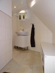Baño blanco con lavabo y encimera en New Business Apartment with Flair en Hersbruck