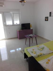ein Wohnzimmer mit einem Tisch und einem Sofa in der Unterkunft Apartment Marijan - Rtina in Rtina