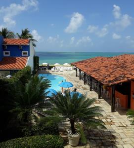 a swimming pool with a view of the ocean at Pousada Baía Dos Corais in Tamandaré