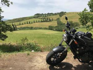 una motocicleta estacionada en un camino de tierra en un campo en Hotel Alexander Palme, en Chianciano Terme