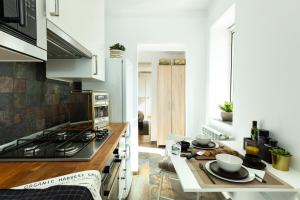 a kitchen with a stove and a table with dishes on it at Qult - Up in the Sky in Bucharest +25 photos