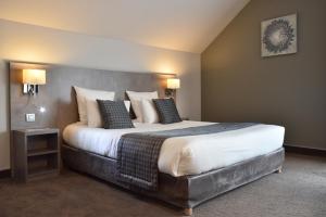 a hotel room with a large bed with pillows at Hotel Saint Daniel in Péruwelz