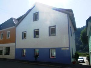 un edificio azul y blanco con ventanas en Ferienwohnung Örtl 7, en Obernzell