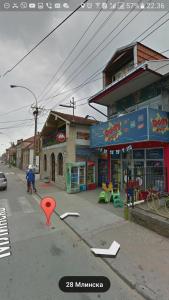 una calle con un marcador rojo frente a una tienda en Dody Apartmani en Leskovac