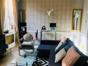 a living room with a blue couch and a tv at City Centre Georgian Style Apartment in Dublin