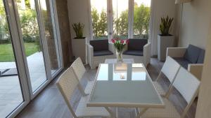 a dining room with a white table and chairs at Casa La Rosa in Montegrotto Terme